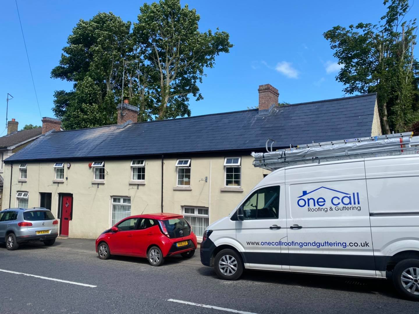 One Call Roofing & Guttering Van outside row of houses