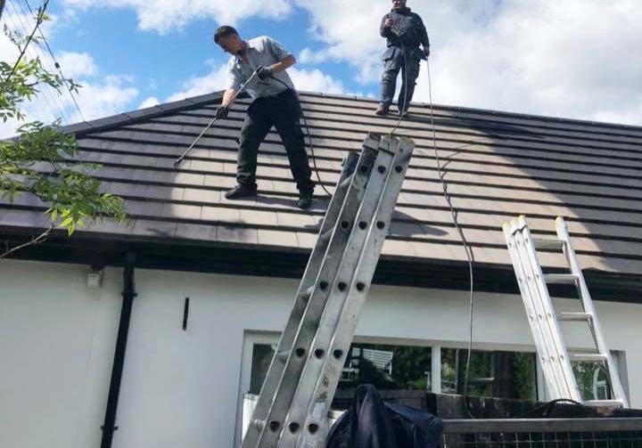 Onecall Roofing & Guttering repainting an old roof with black paint